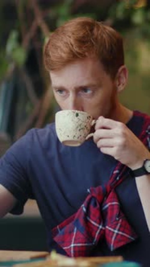 Man Drinking Coffee at Table Indoors