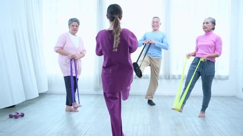 Seniors Exercising with Resistance Bands in Bright Room