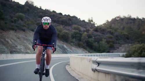 Athletic Cyclist is Cycling in the Mountains Landscape
