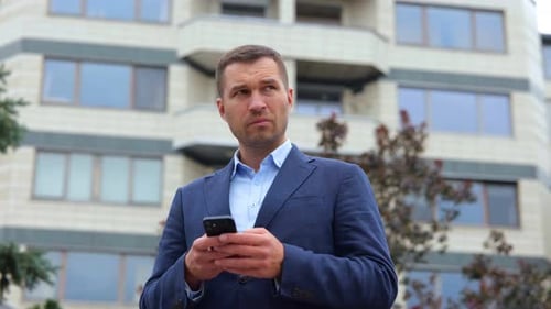 Close Up Portrait of Caucasian Handsome Male Manager with Serious Face Standing in Street in City