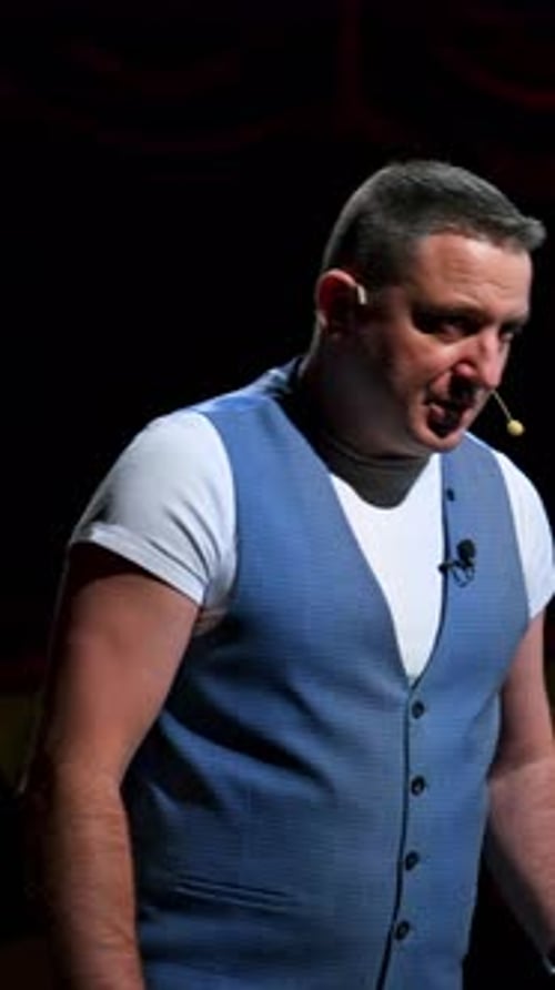 Actor on classic theatre stage. Man is speaking in spotlights during the performance.