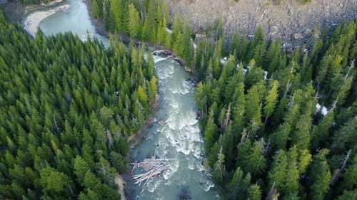 Stunning turquoise river flyover drone shot descending towards forest