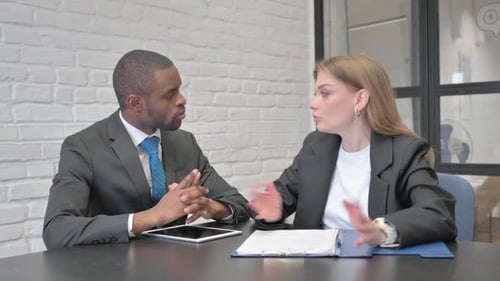 Two Professionals Meeting at a Table Discussing Documents