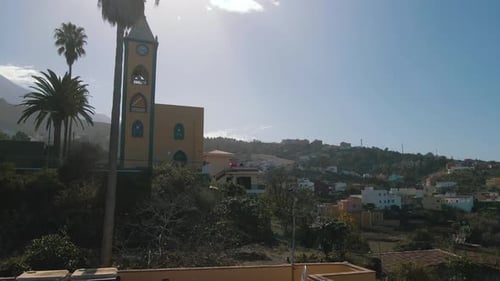 Luftaufnahme eines Dolly in Richtung Kirchturm, Kirchenglocke und Uhr, Spanien