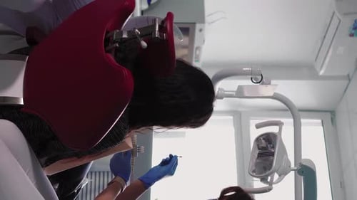 Professional Woman Dentist in Medical Gloves Examines Patient in Dental Clinic