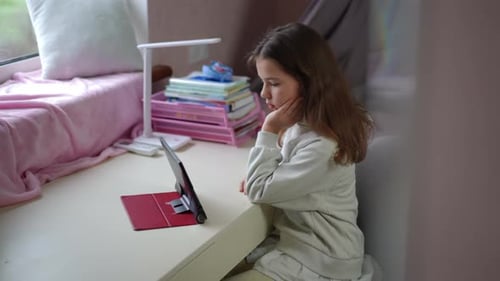 Girl Using Tablet Device at Desk in Room