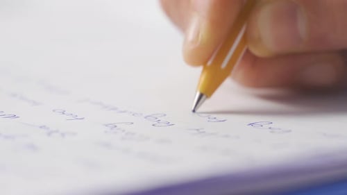 Close-up of hand writing notes in the office.