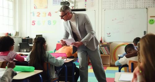 Mature man, teacher and documents with test in elementary school for learning assessment or exam