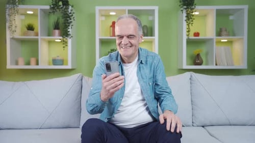 Senior Man Talking on Smartphone Indoors