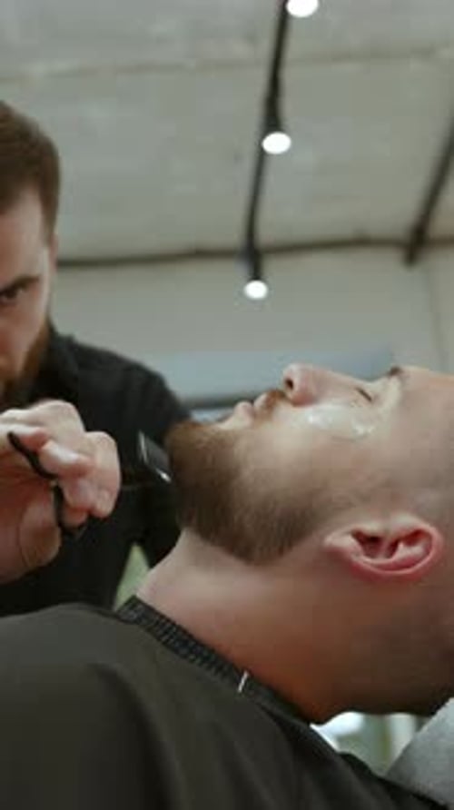 Man Getting Beard Trimmed by Barber Indoors
