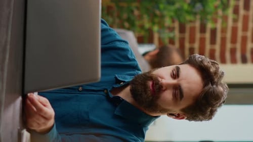 Man Talking into Laptop in Modern Office