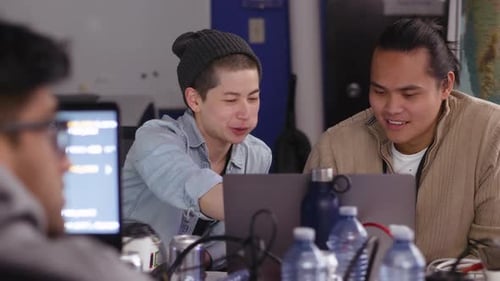 Computerprogrammierer, die am Laptop essen und sprechen, 25-29 Jahre