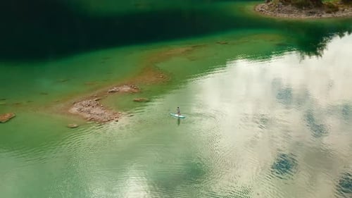 Man Swimming on the Sub Board or a Paddleboard in the Middle of the Lake