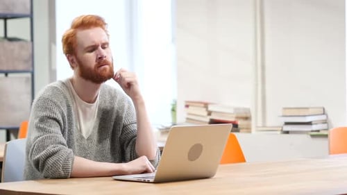 Pensive Man Thinking and Working on Laptop