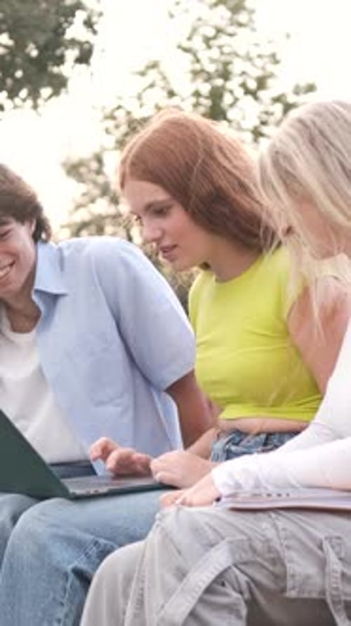 Three Young Adults Collaborating on a Laptop
