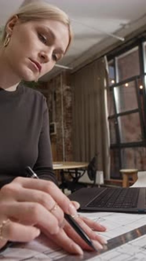 Woman Architect Drafting Building Blueprint with Pencil and Ruler