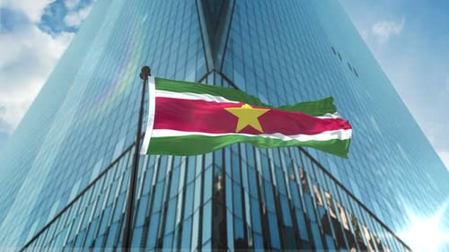 Suriname Flag Waving in Front of Modern Corporate Building