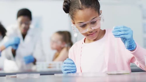 Diverse female teacher and happy schoolchildren having science class in school lab