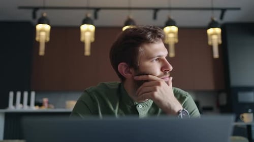 Homem trabalha com laptop em casa ou no espaço de coworking Retrato frontal de um cara barbudo bonito