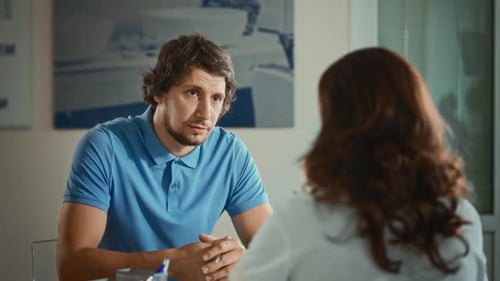 Ein Mann in einem Polo bei einem Interview im Büro Eine Frau trifft sich mit einem potenziellen neuen Mitarbeiter
