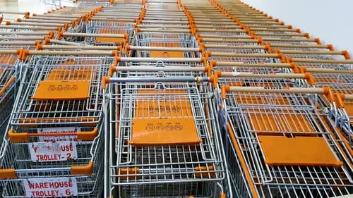Unused shopping trollies lying vacant at the mall due to Covid. Tilt up.