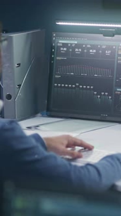 Software Programmer Sits in Front of Computer with Big Data Server