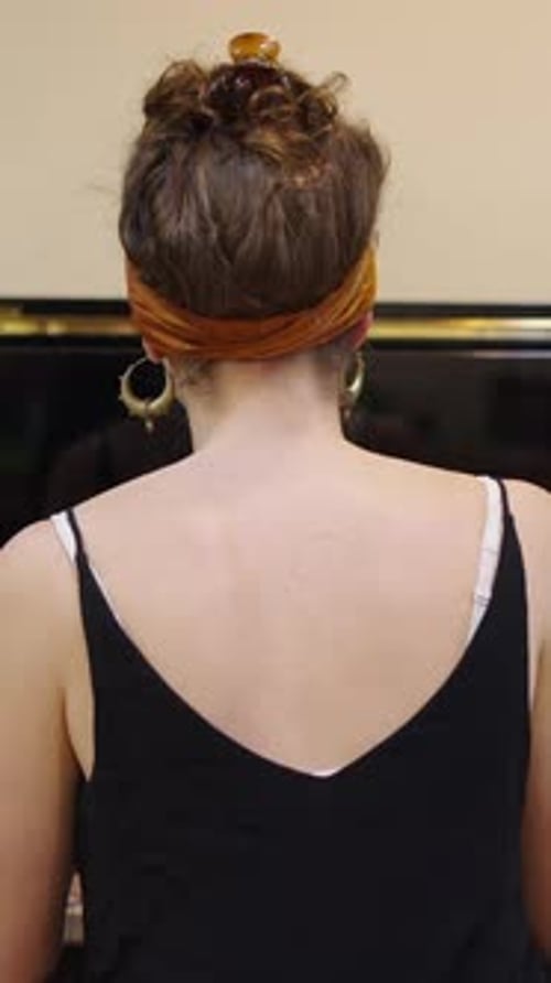 Woman with Scarf Playing Piano in her Home