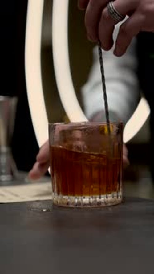 Bartender Stirring Cocktail with Ice on Preparation Table