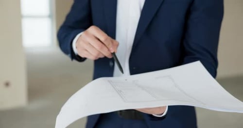 Agente imobiliário feliz e bem-sucedido do Oriente Médio com o plano de construção em mãos falando sobre um novo