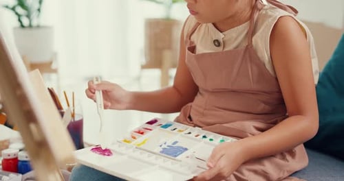 girl painting canvas with color palette use paint brush focus on painting abstract on weekend.