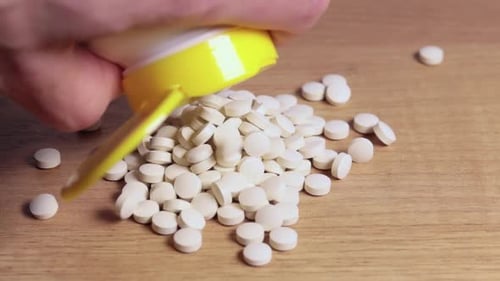 Weiße kleine kreisförmige Tabletten oder Pillen, die aus der Packung herausfallen