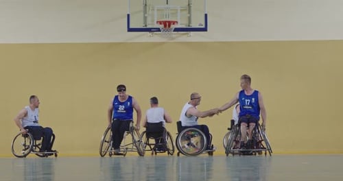 Wheelchair Basketball Athletes Shaking Hands and Bouncing Ball