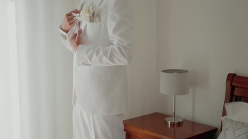 Groom in White Suit Prepares for Wedding Ceremony