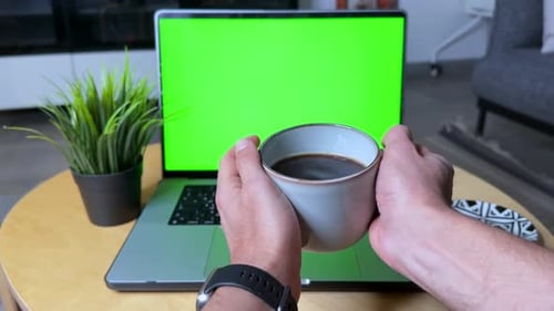 Relaxing Morning Coffee in Front of Laptop with Green Screen.
