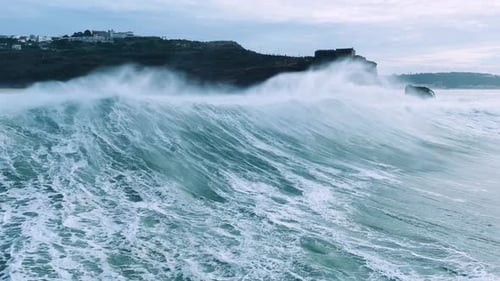 Towering Ocean Waves Rolling Toward Coastal Cliffs
