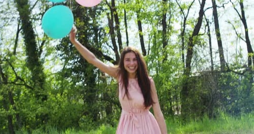 Young Woman Runs with Balloons in Green Park