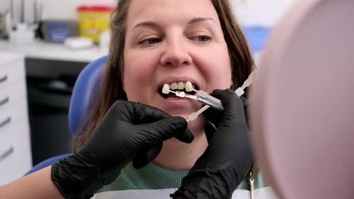 Doctor Hand Holding Teeth Color Samples Helping Patient Veneer Teeth Treatment and Whitening
