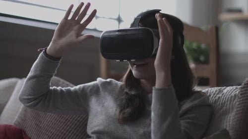 Woman using VR headset on couch at home