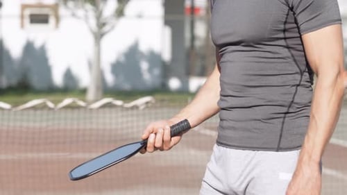 Pickleball Paddle and Yellow Ball Close Up Man Playing Pickleball Game Hitting Pickleball Yellow