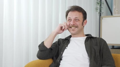 Man Sitting and Smiling in a Bright Room