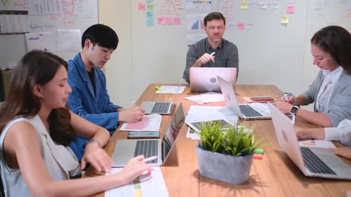 Professional manager discuss with his team about business project in meeting room of office