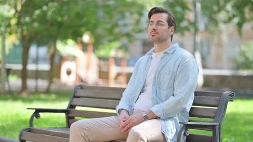 Casual Middle Aged Man Sitting in Park