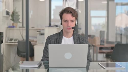 Call Center Man with Headset Working on Laptop