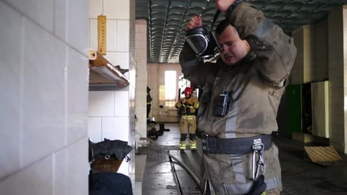 Young Fireguard Taking Off Oxygen Mask After Emergency in Fire Station Male Tired Firefighter in