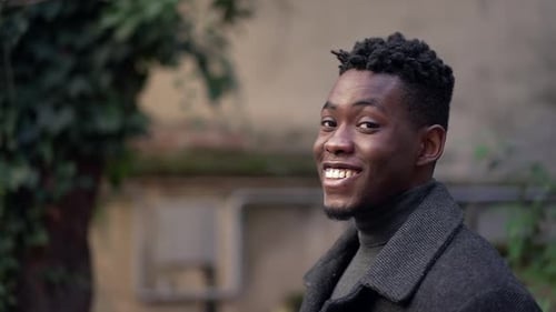 Young Man Smiling Outdoors in Urban Setting
