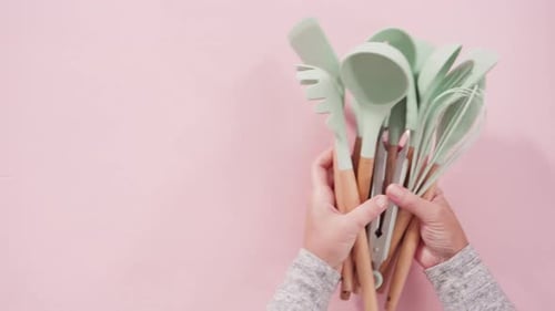 Light Green Kitchen Utensils on Pink Background