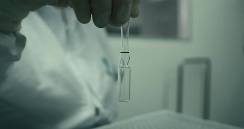 Closeup view of half filled ampule in a laboratory. Blurred background.