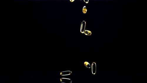 Falling Gel Capsules on Black Background