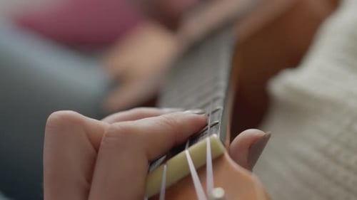 Woman Plays Ukulele in Close Up View