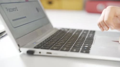 Hands Typing Password on Laptop Computer